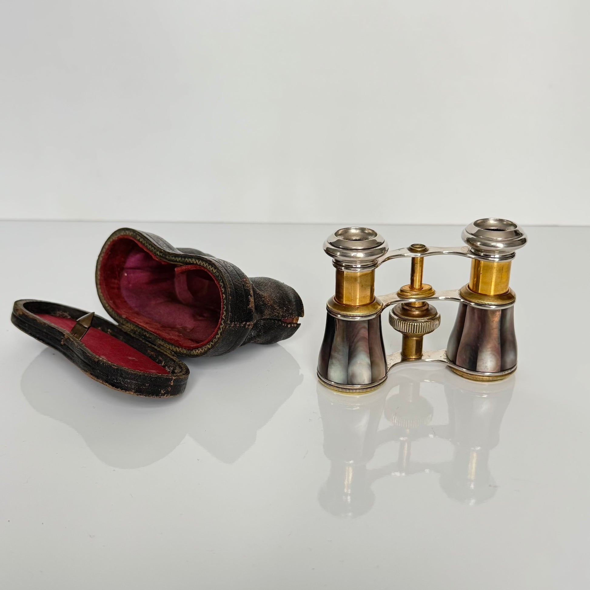 English: Pair of black mother-of-pearl opera glasses with original leather case, late 19th to early 20th century, compact and extendable design ; 日本語: ブラックマザーオブパール（黒蝶貝）のオペラグラスのペア、オリジナル革ケース付き、19世紀末〜20世紀初頭、コンパクトで伸縮可能なデザイン ; Français: Paire de jumelles en nacre noire avec étui en cuir d’origine, fin XIXe – début XXe siècle, design compact et extensible.