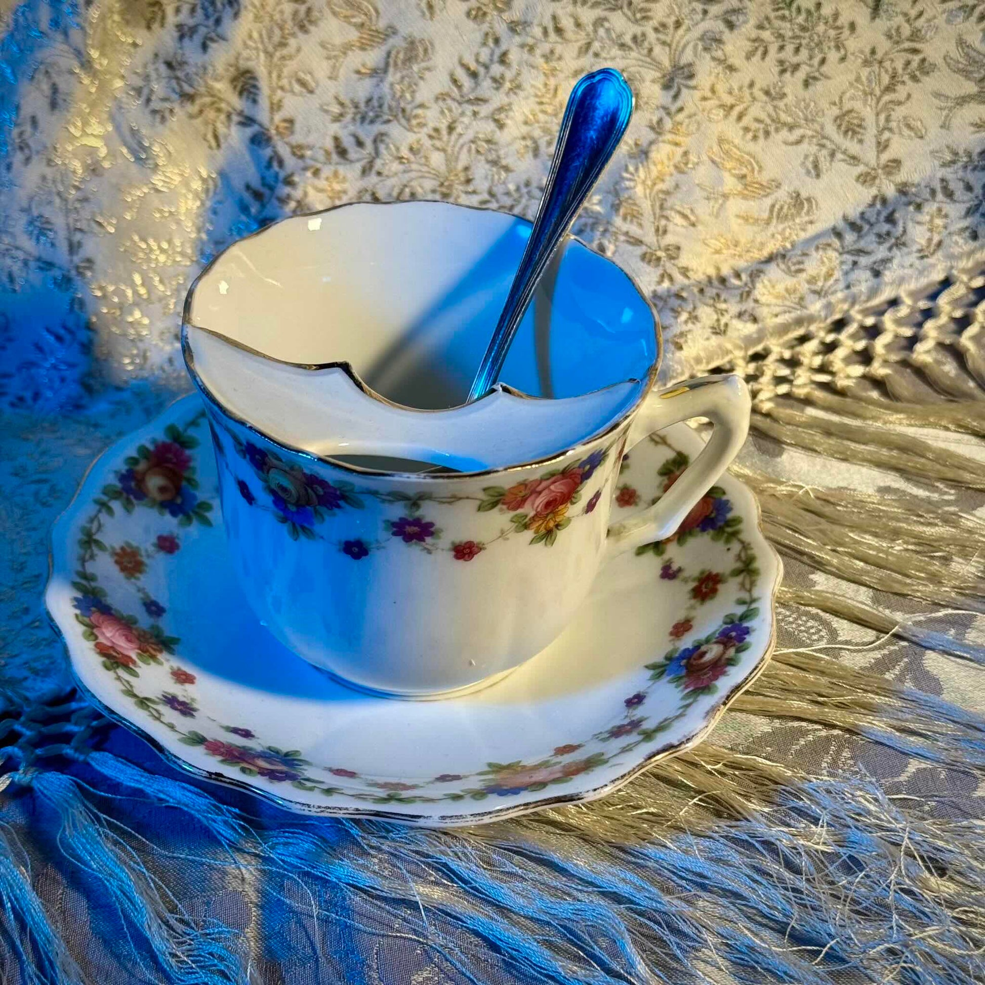 English: K. Steinmann Silesia porcelain moustache cup and saucer, floral design, made c.1910–1930, marked K.St. T. SILESIA; 日本語: K.シュタインマン製シレジア磁器のマスタッシュカップ＆ソーサー、フラワーガーランド、1910〜1930年頃製造、K.St. T. SILESIAのサインあり; Français: Tasse à moustache et soucoupe en porcelaine de Silesia par K. Steinmann, décor floral, fabriquée vers 1910–1930, signée K.St. T. SILESIA.