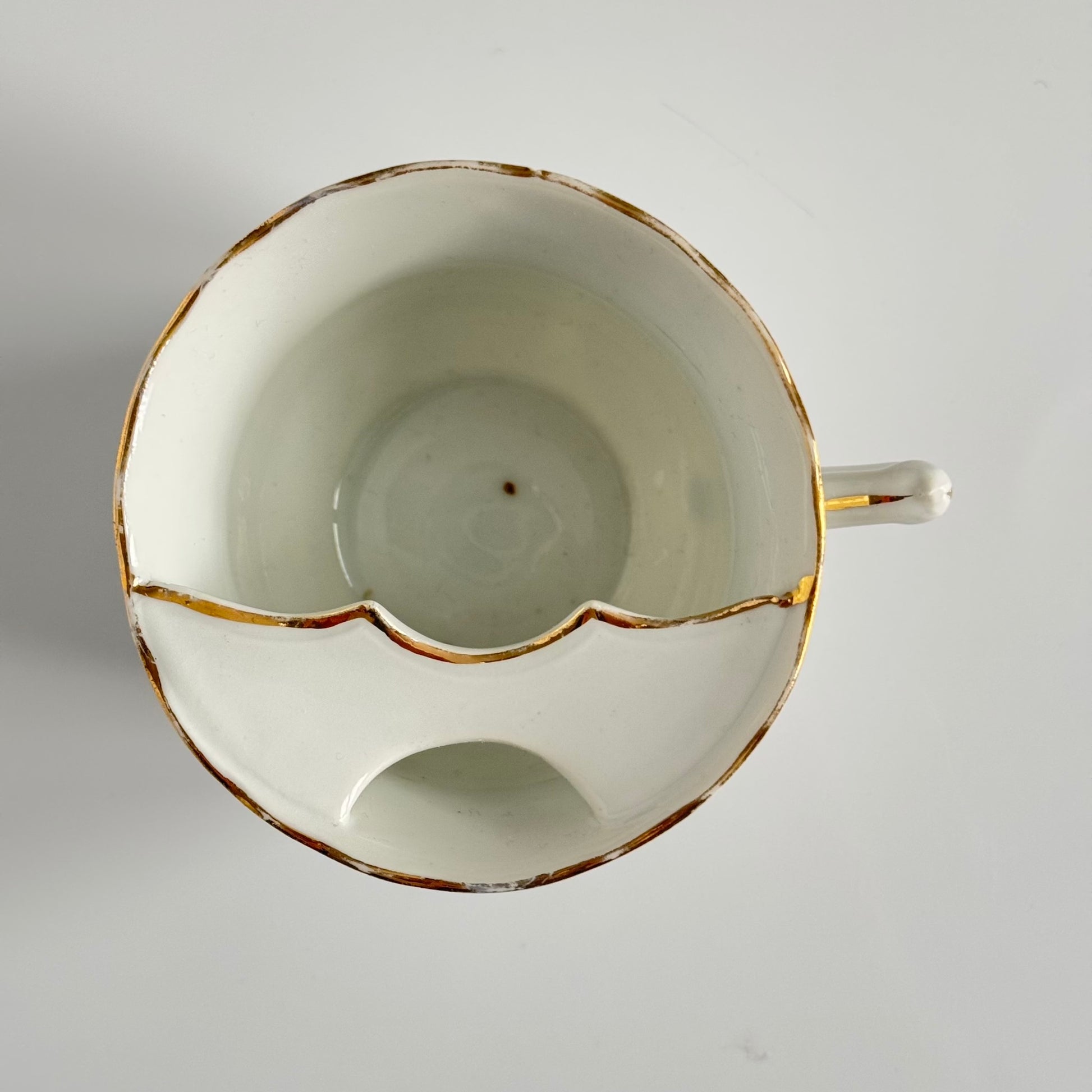 English: K. Steinmann Silesia porcelain moustache cup and saucer, floral design, made c.1910–1930, marked K.St. T. SILESIA; 日本語: K.シュタインマン製シレジア磁器のマスタッシュカップ＆ソーサー、フラワーガーランド、1910〜1930年頃製造、K.St. T. SILESIAのサインあり; Français: Tasse à moustache et soucoupe en porcelaine de Silesia par K. Steinmann, décor floral, fabriquée vers 1910–1930, signée K.St. T. SILESIA.