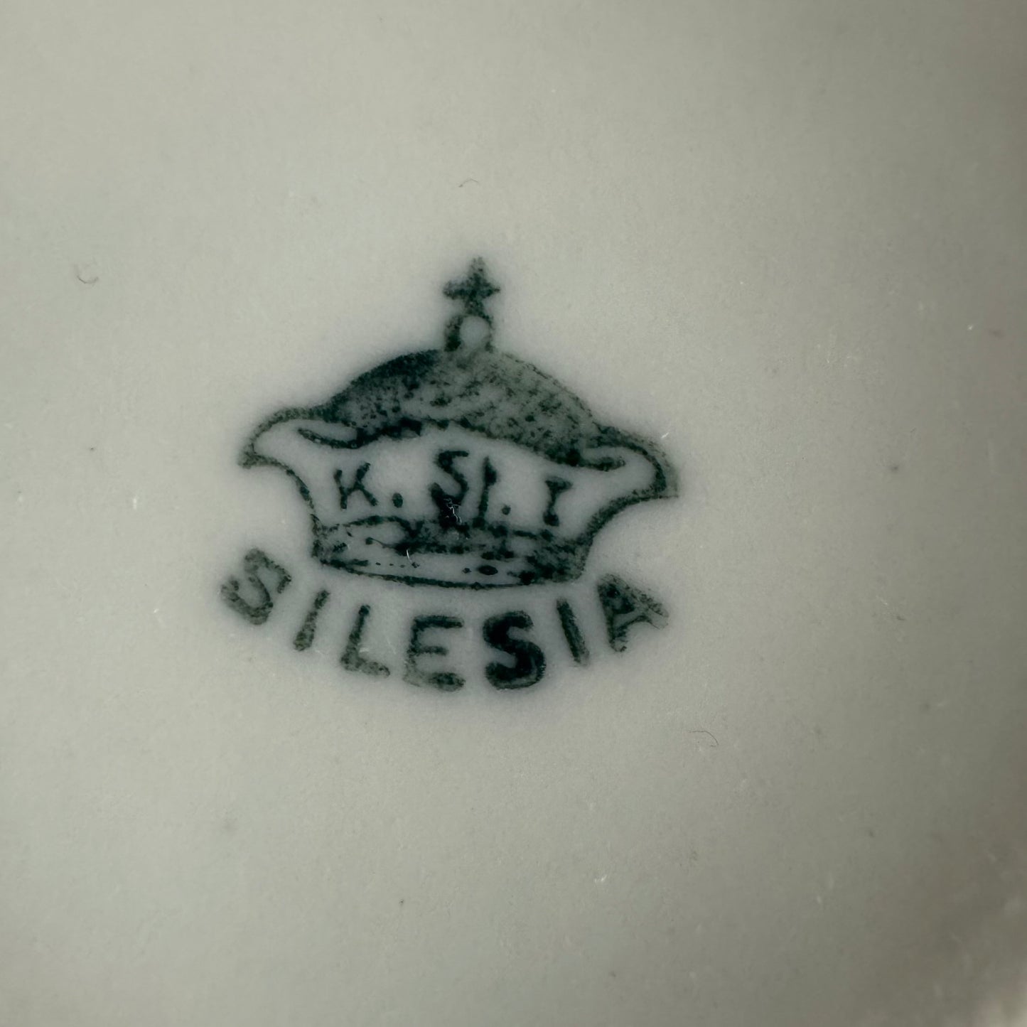English: K. Steinmann Silesia porcelain moustache cup and saucer, floral design, made c.1910–1930, marked K.St. T. SILESIA; 日本語: K.シュタインマン製シレジア磁器のマスタッシュカップ＆ソーサー、フラワーガーランド、1910〜1930年頃製造、K.St. T. SILESIAのサインあり; Français: Tasse à moustache et soucoupe en porcelaine de Silesia par K. Steinmann, décor floral, fabriquée vers 1910–1930, signée K.St. T. SILESIA.