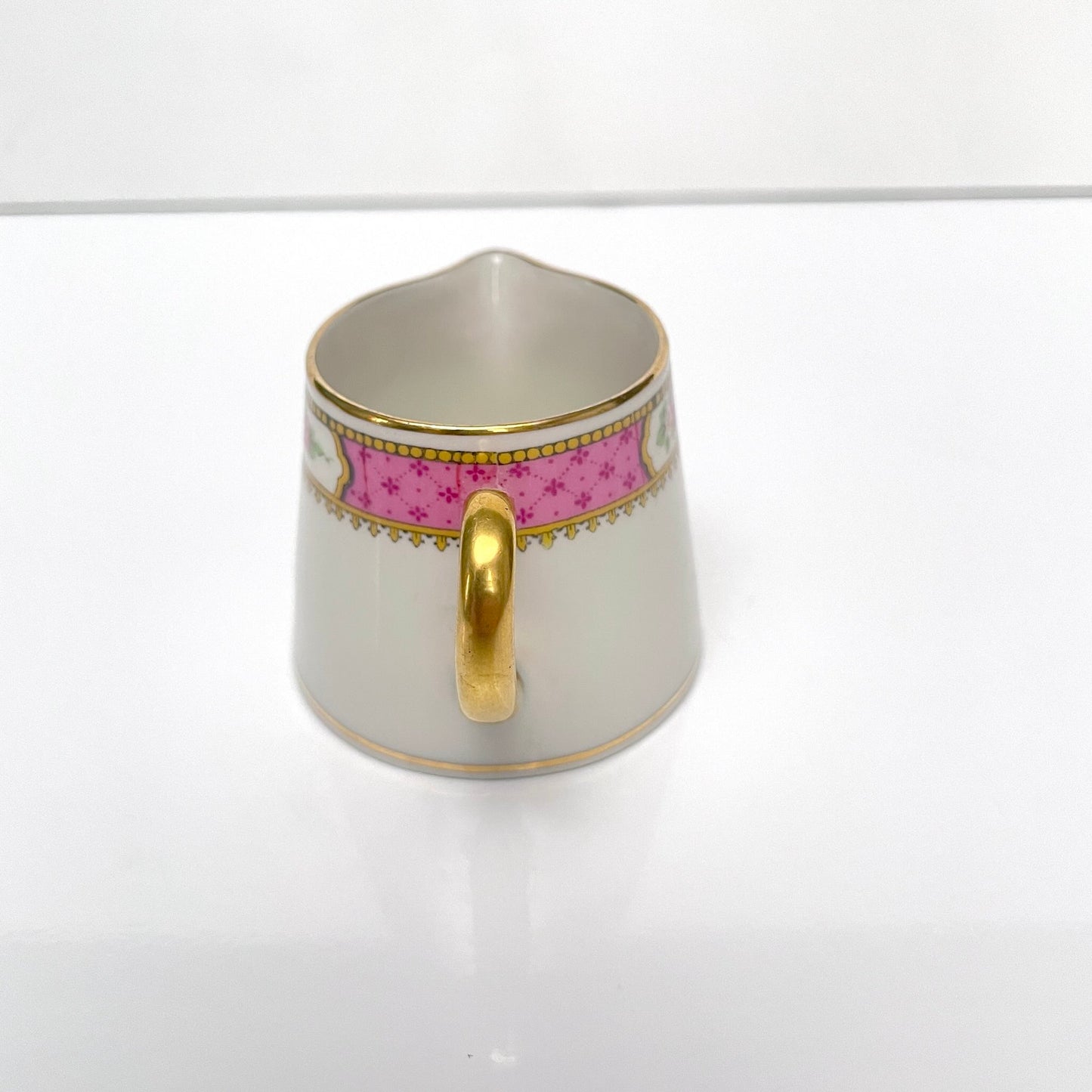 This is a Limoges porcelain milk jug with a delicate floral rose design, made by F. Paulhat. It showcases fine craftsmanship typical of Limoges porcelain.