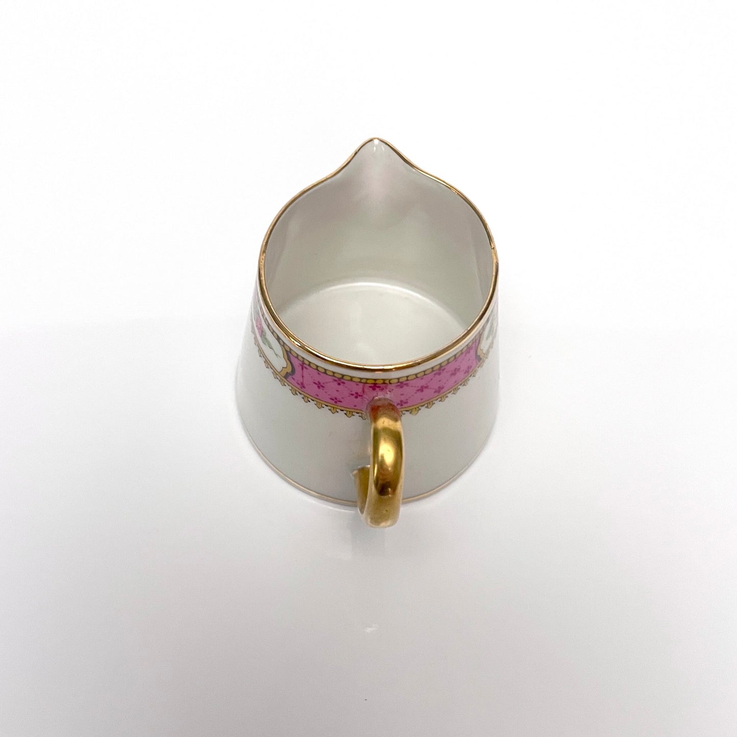 This is a Limoges porcelain milk jug with a delicate floral rose design, made by F. Paulhat. It showcases fine craftsmanship typical of Limoges porcelain.