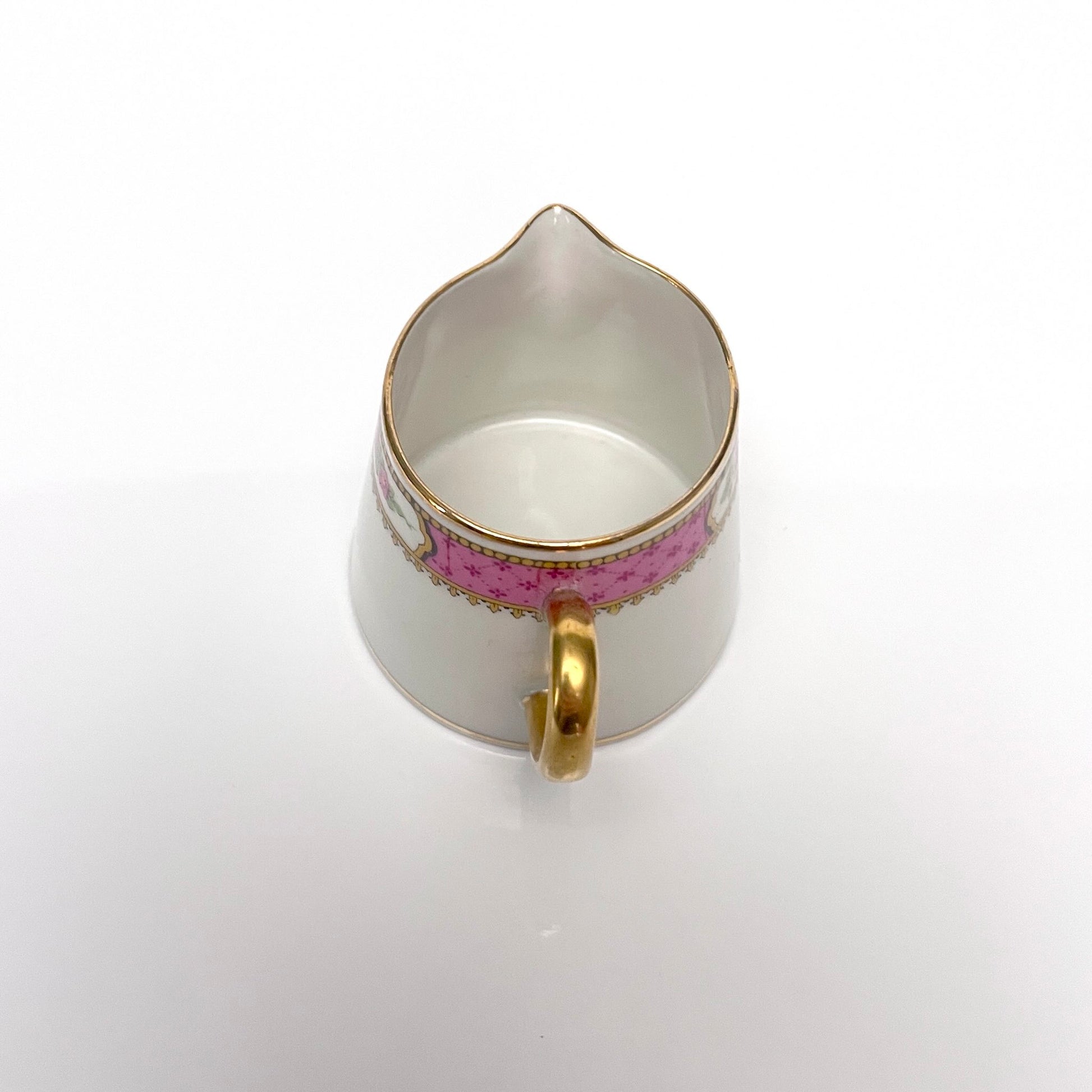 This is a Limoges porcelain milk jug with a delicate floral rose design, made by F. Paulhat. It showcases fine craftsmanship typical of Limoges porcelain.