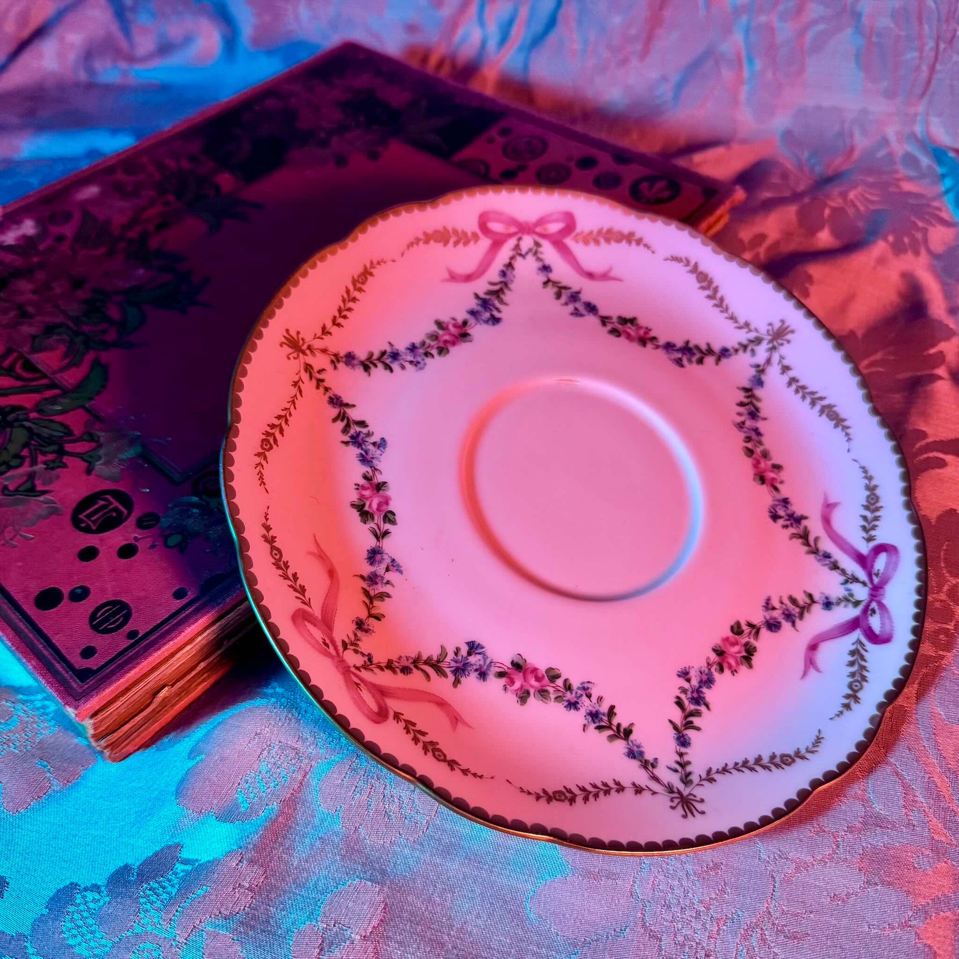 Limoges porcelain plate, Comte d’Artois model, with a Sèvres-inspired ribbon and floral design. Ideal for serving macarons or small desserts. Vintage from the 20th century onwards.