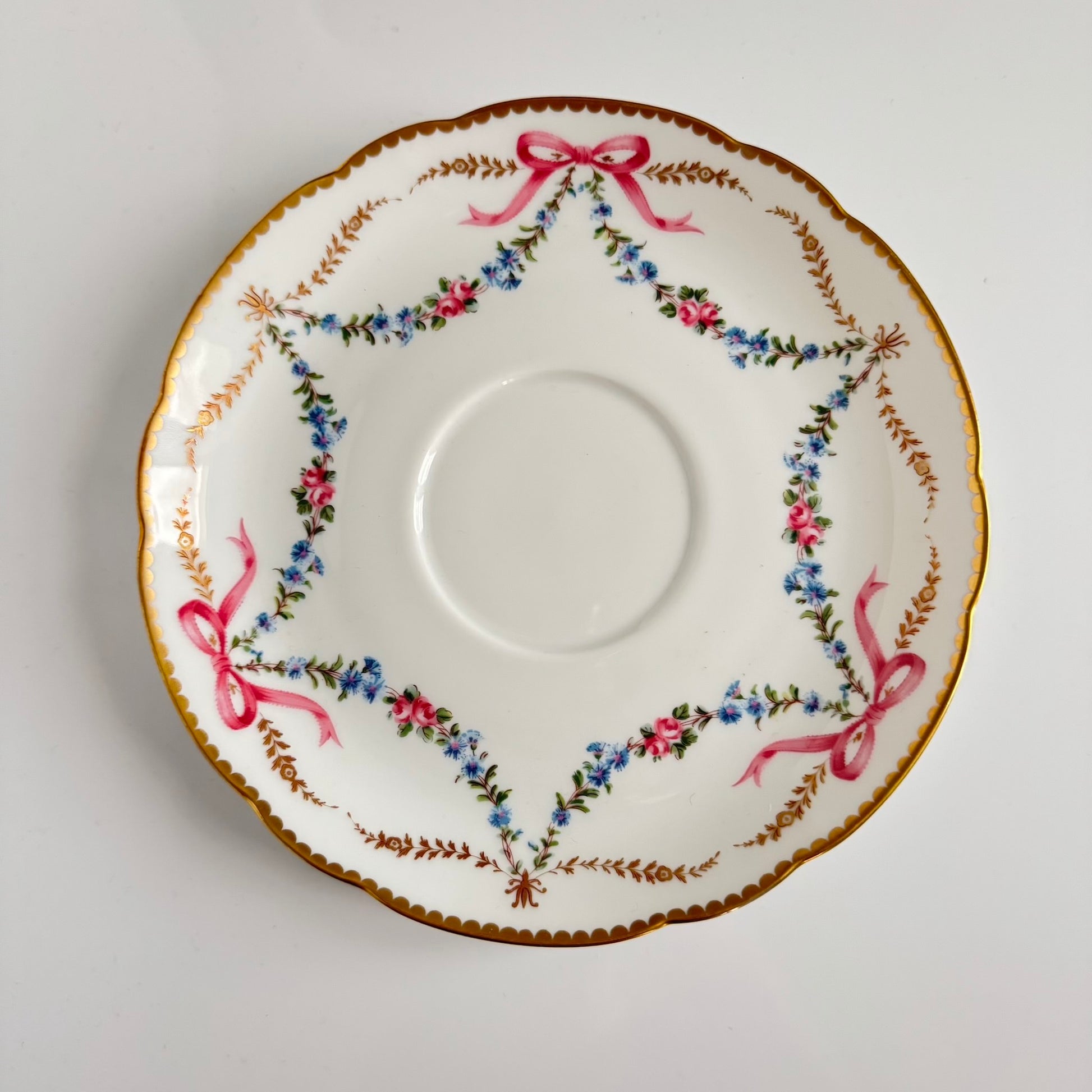 Limoges porcelain plate, Comte d’Artois model, with a Sèvres-inspired ribbon and floral design. Ideal for serving macarons or small desserts. Vintage from the 20th century onwards.