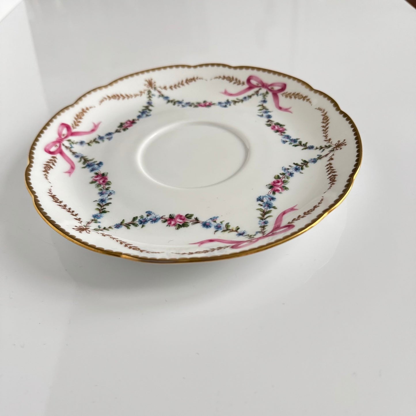 Limoges porcelain plate, Comte d’Artois model, with a Sèvres-inspired ribbon and floral design. Ideal for serving macarons or small desserts. Vintage from the 20th century onwards.