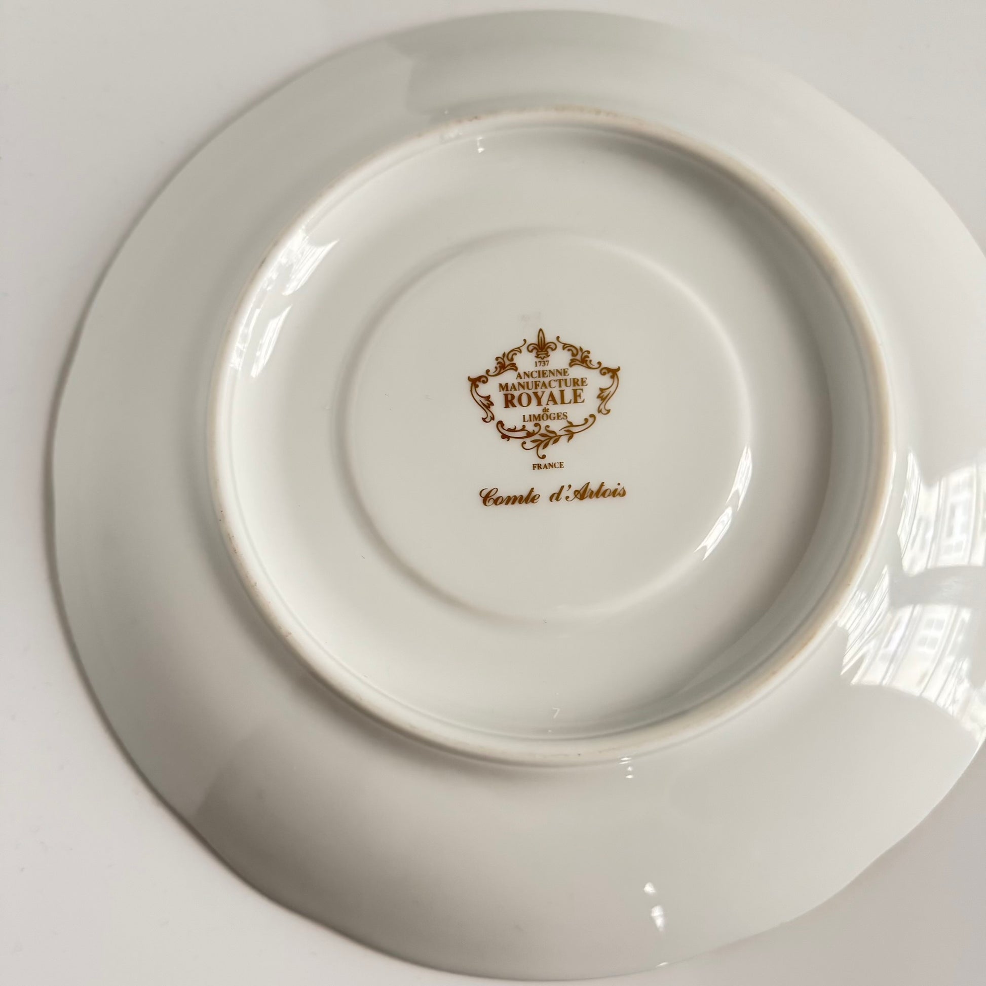 Limoges porcelain plate, Comte d’Artois model, with a Sèvres-inspired ribbon and floral design. Ideal for serving macarons or small desserts. Vintage from the 20th century onwards.