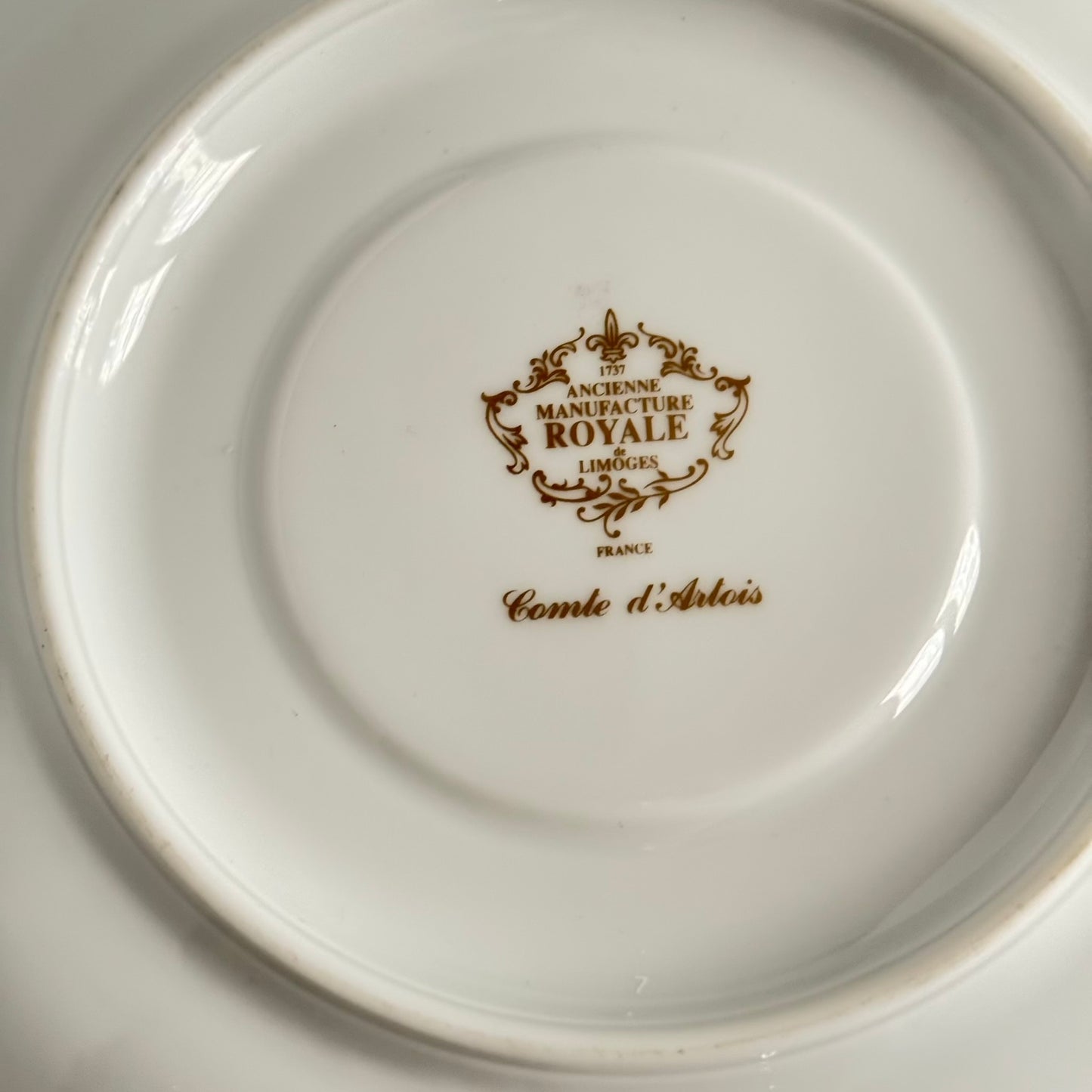 Limoges porcelain plate, Comte d’Artois model, with a Sèvres-inspired ribbon and floral design. Ideal for serving macarons or small desserts. Vintage from the 20th century onwards.