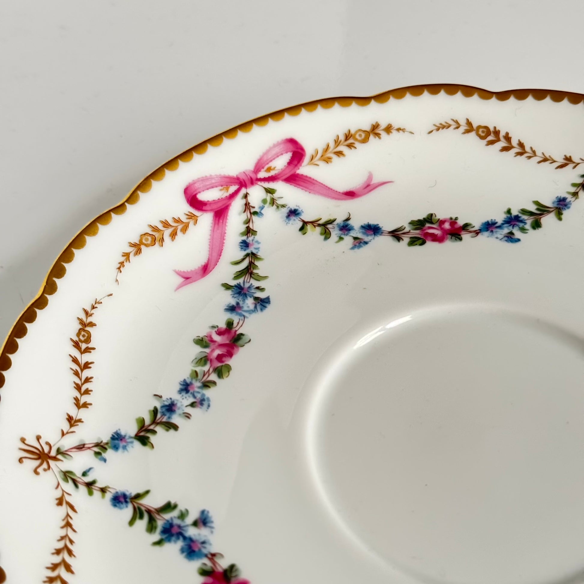 Limoges porcelain plate, Comte d’Artois model, with a Sèvres-inspired ribbon and floral design. Ideal for serving macarons or small desserts. Vintage from the 20th century onwards.