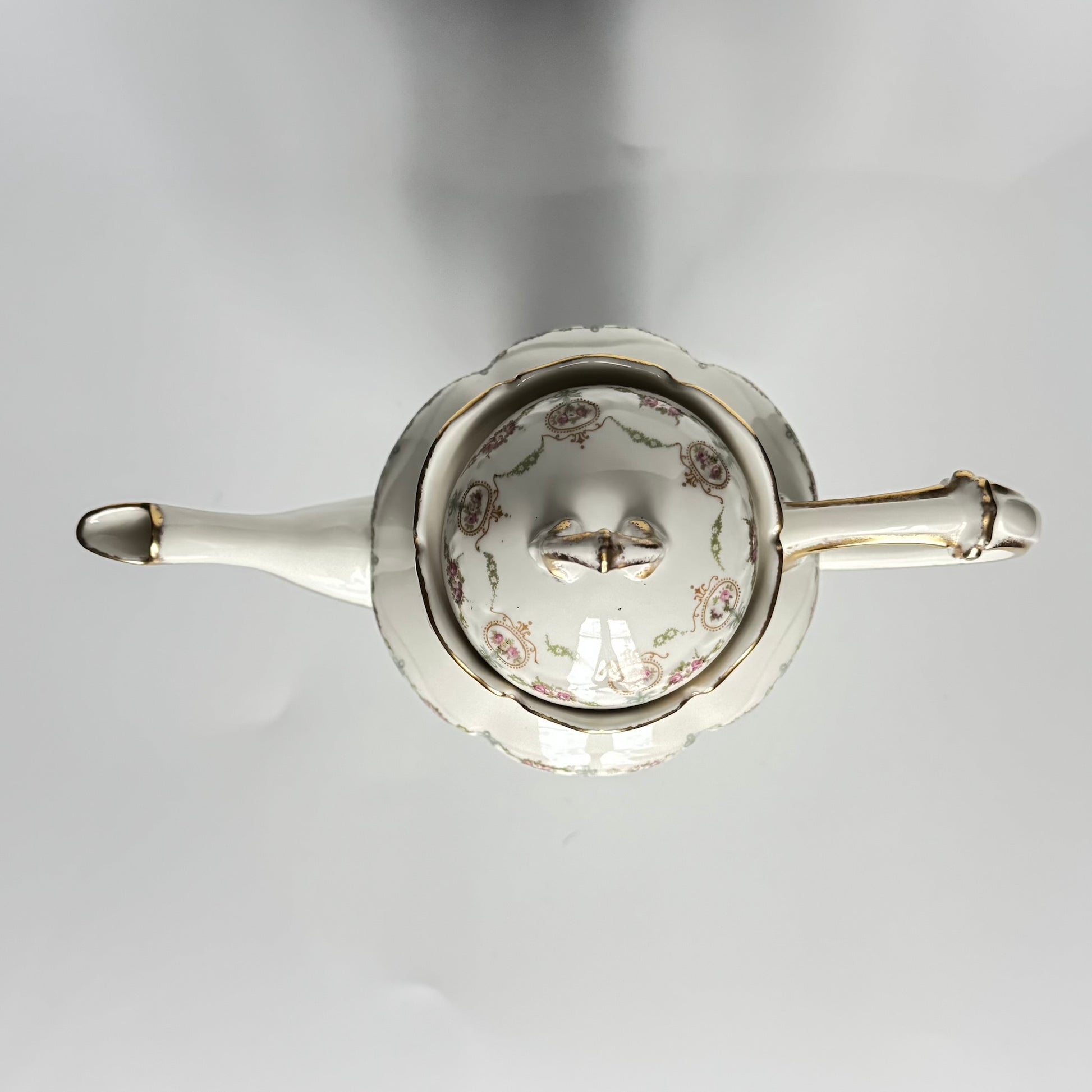 Limoges porcelain tea/coffee pot and sugar pot set with a floral and ribbon design, exuding elegance.