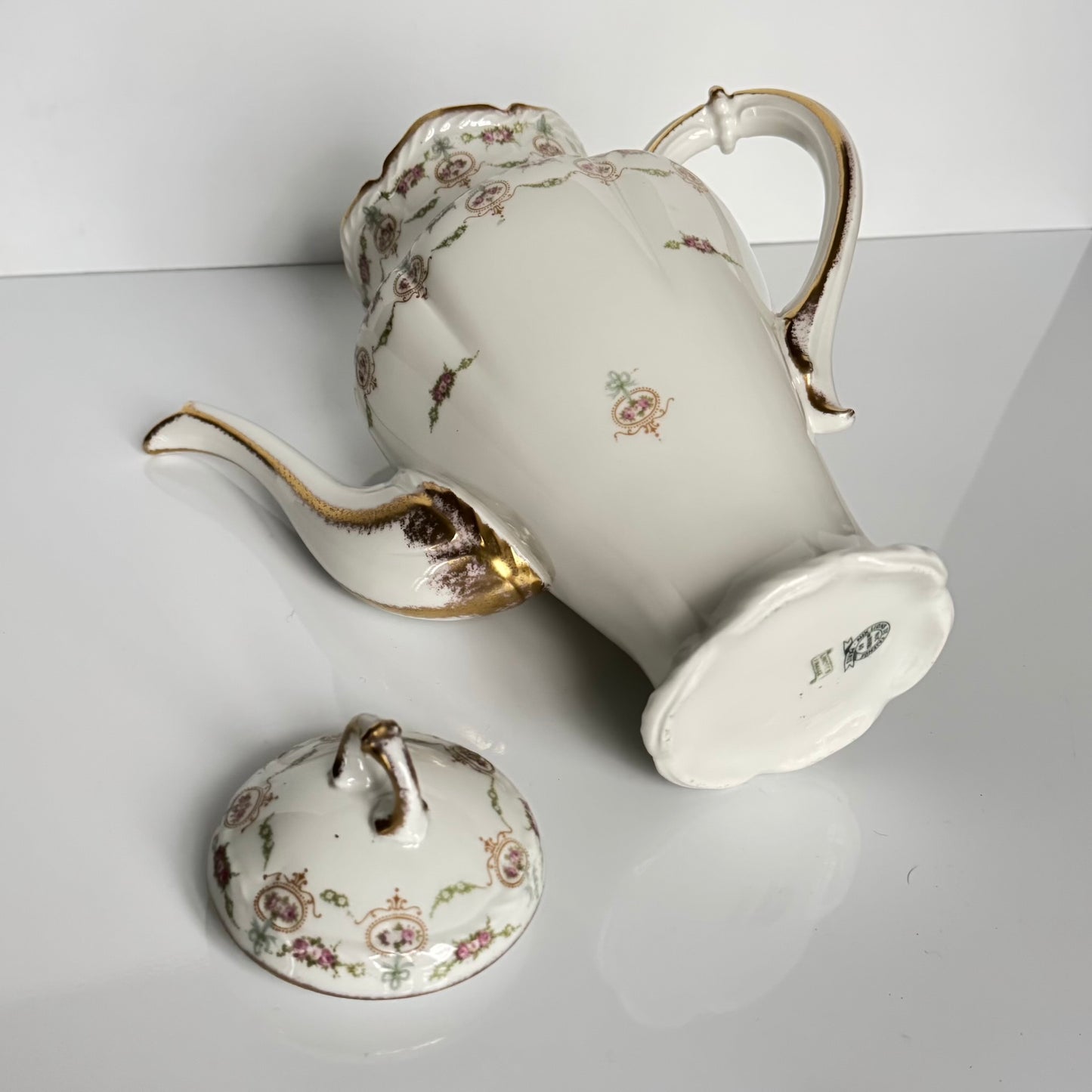 Limoges porcelain tea/coffee pot and sugar pot set with a floral and ribbon design, exuding elegance.