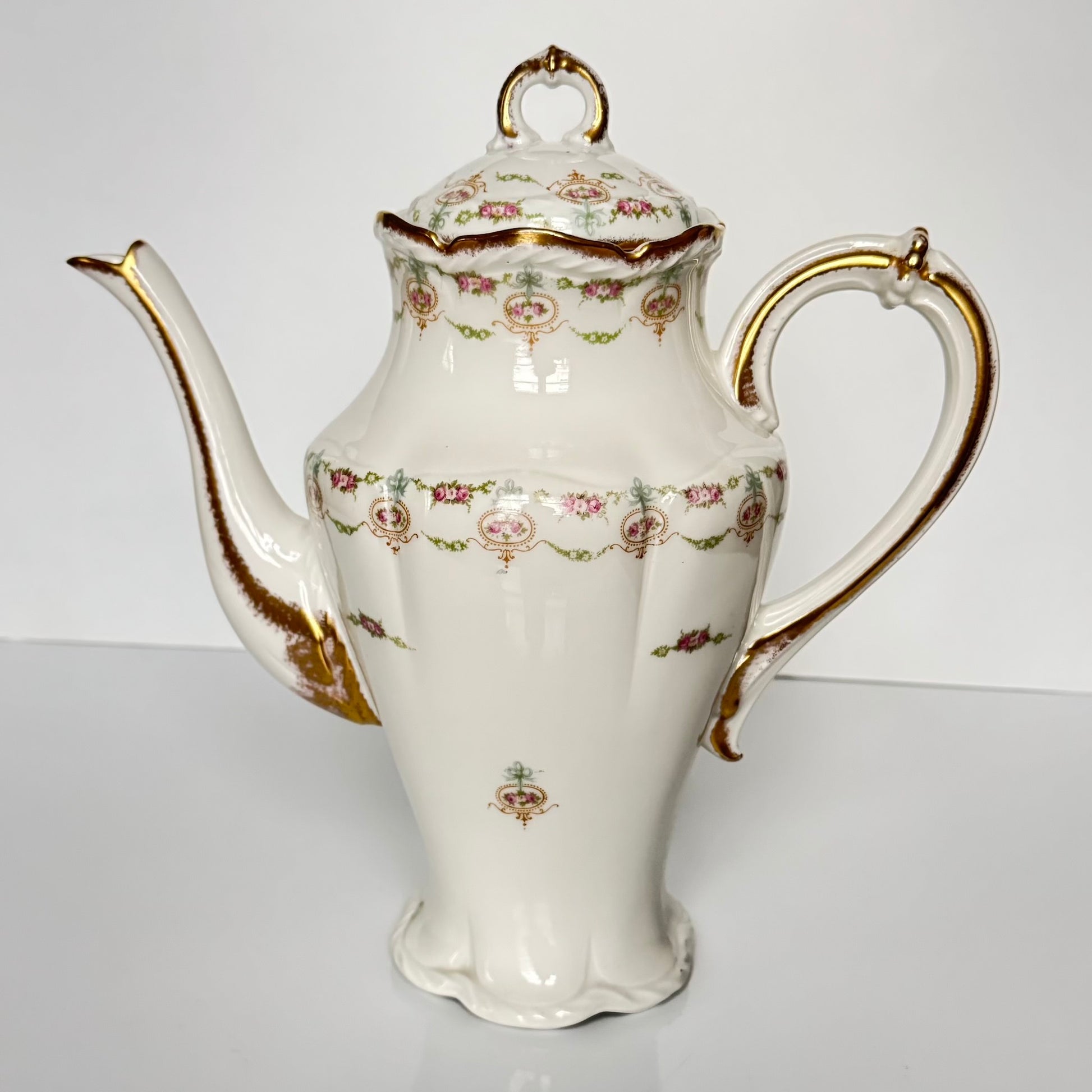 Limoges porcelain tea/coffee pot and sugar pot set with a floral and ribbon design, exuding elegance.