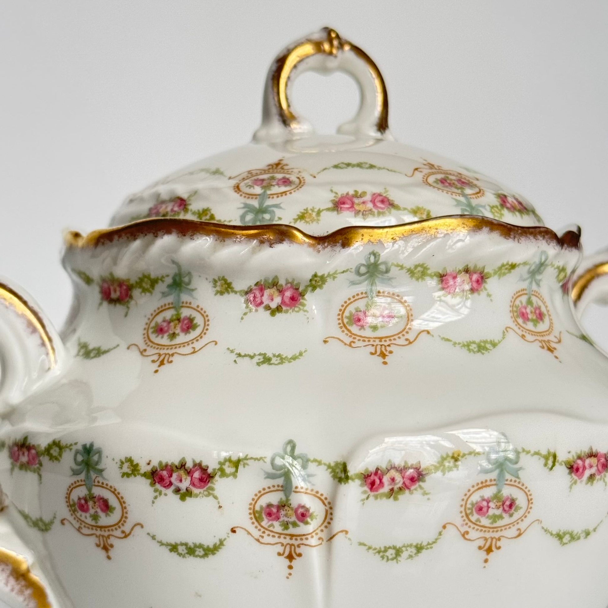 Limoges porcelain tea/coffee pot and sugar pot set with a floral and ribbon design, exuding elegance.