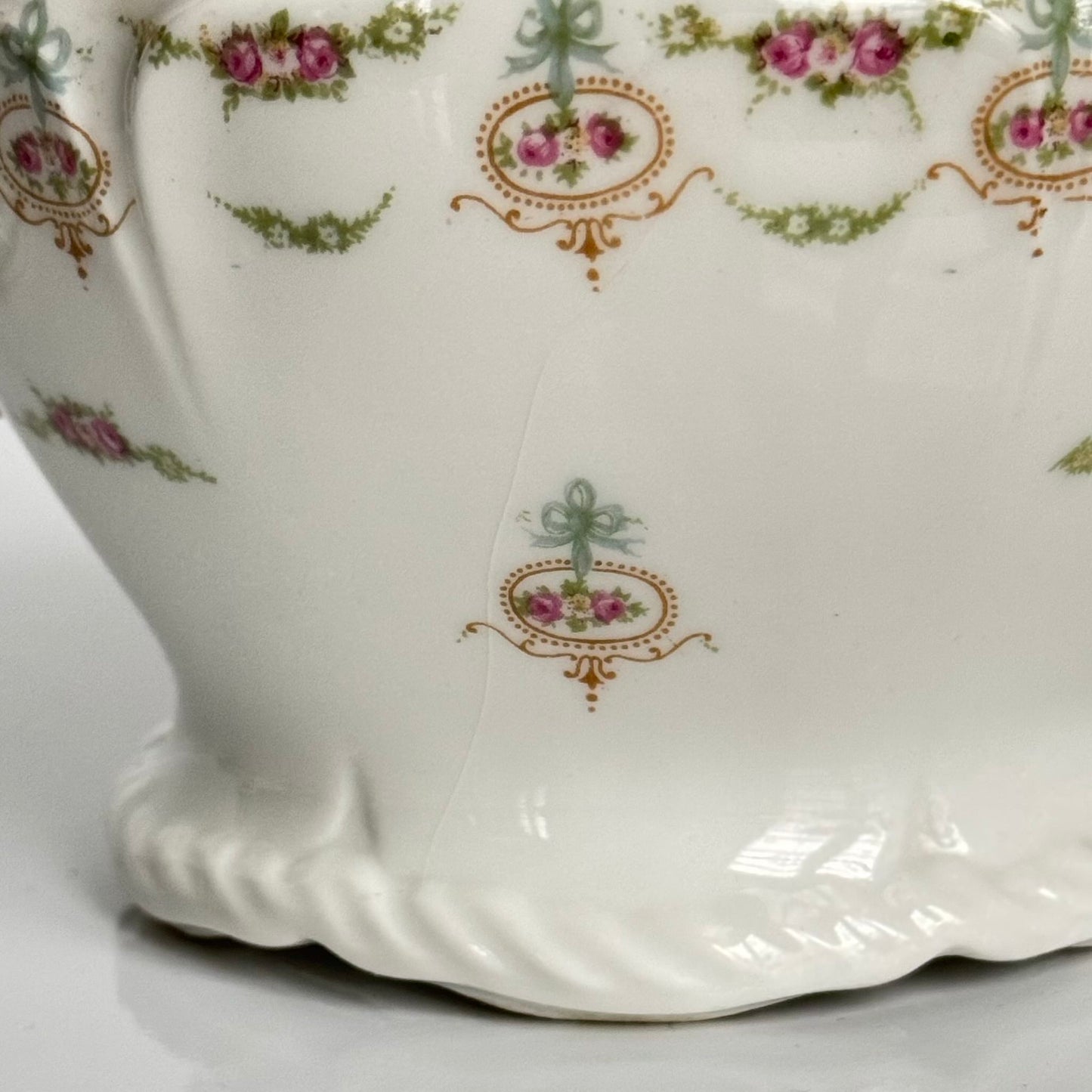 Limoges porcelain tea/coffee pot and sugar pot set with a floral and ribbon design, exuding elegance.
