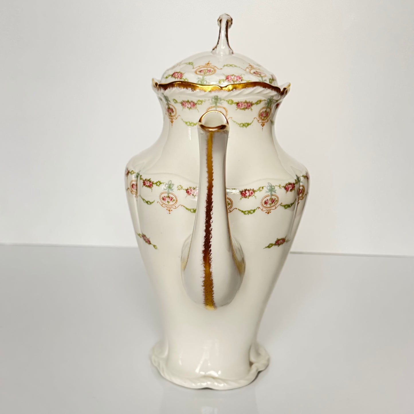 Limoges porcelain tea/coffee pot and sugar pot set with a floral and ribbon design, exuding elegance.