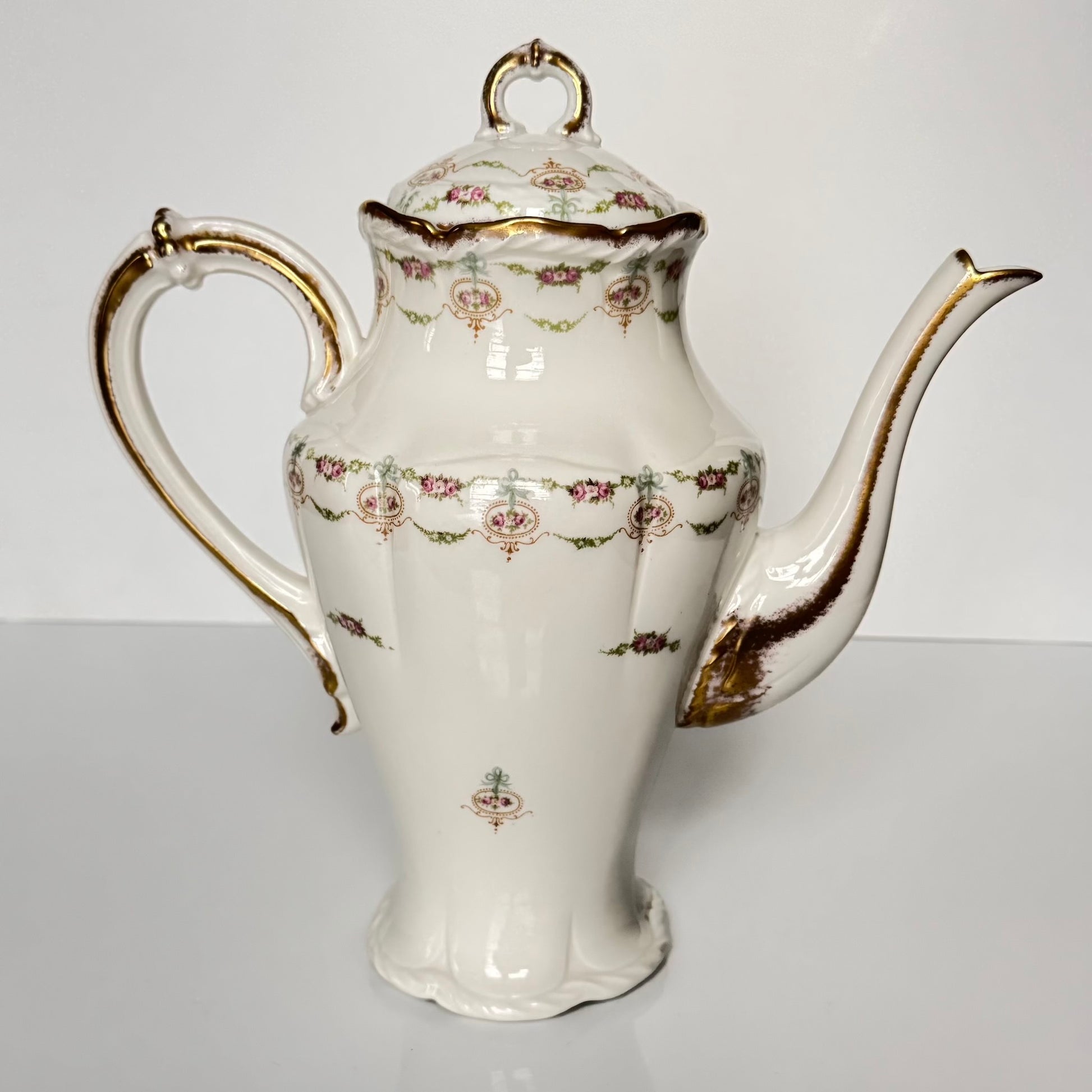 Limoges porcelain tea/coffee pot and sugar pot set with a floral and ribbon design, exuding elegance.