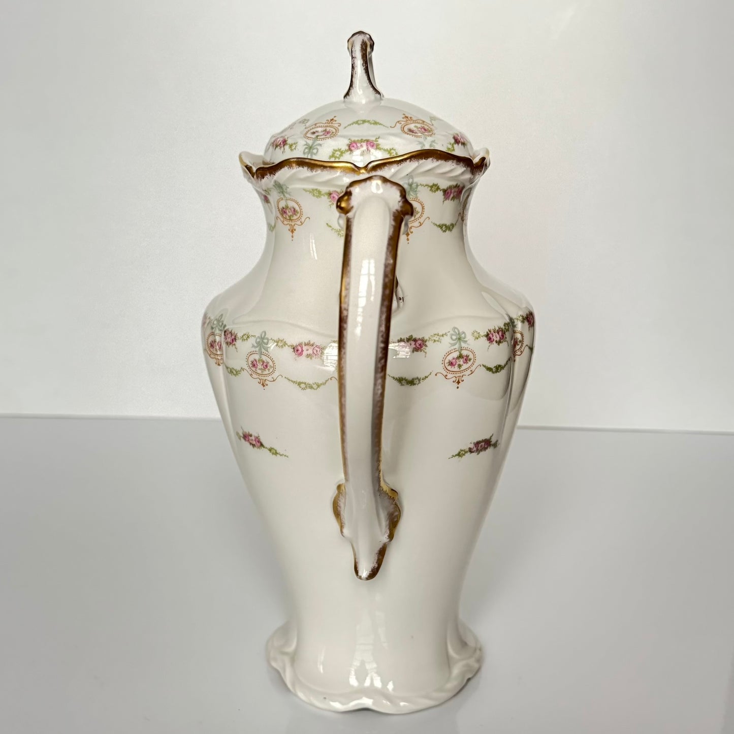 Limoges porcelain tea/coffee pot and sugar pot set with a floral and ribbon design, exuding elegance.
