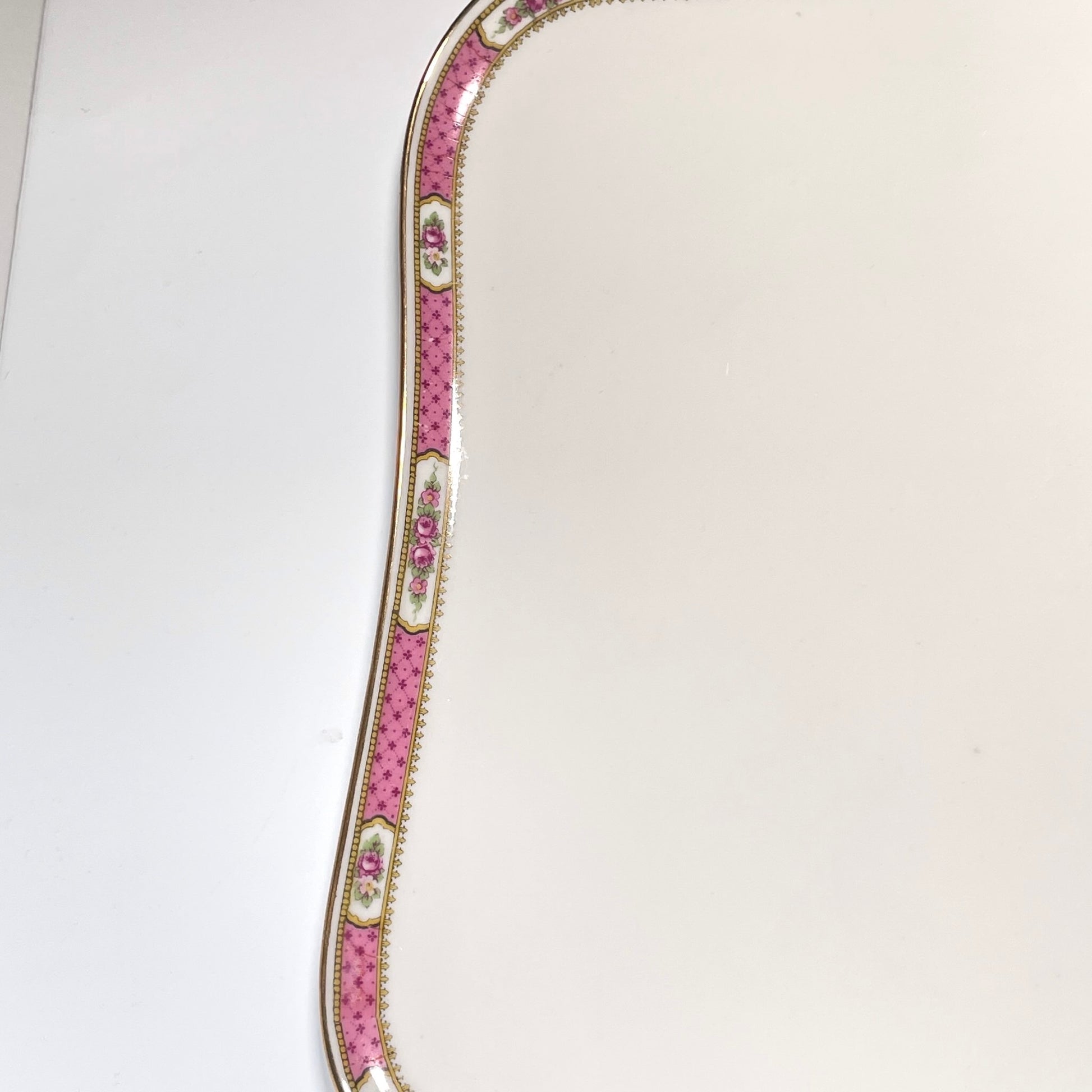 This is a Limoges porcelain tray with a delicate floral rose design and a soft pink border, perfect for tea or coffee service. It is signed by F. Paulhat Limoges, France.