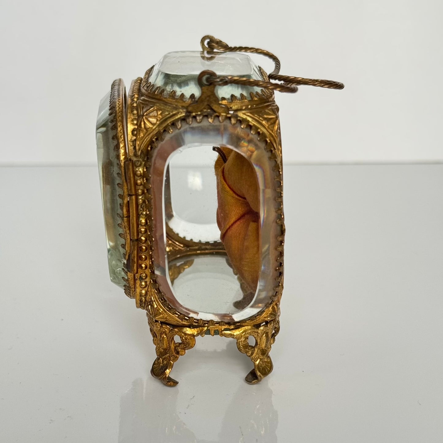 English: Napoleon III style pocket watch stand in gilded brass and beveled glass, late 19th to early 20th century. ; 日本語: 19世紀後期〜20世紀初頭のナポレオン三世様式、金メッキ真鍮と面取りガラス製の懐中時計スタンド。 ; Français: Porte-montre de style Napoléon III en laiton doré et verre biseauté, fin XIXe – début XXe.