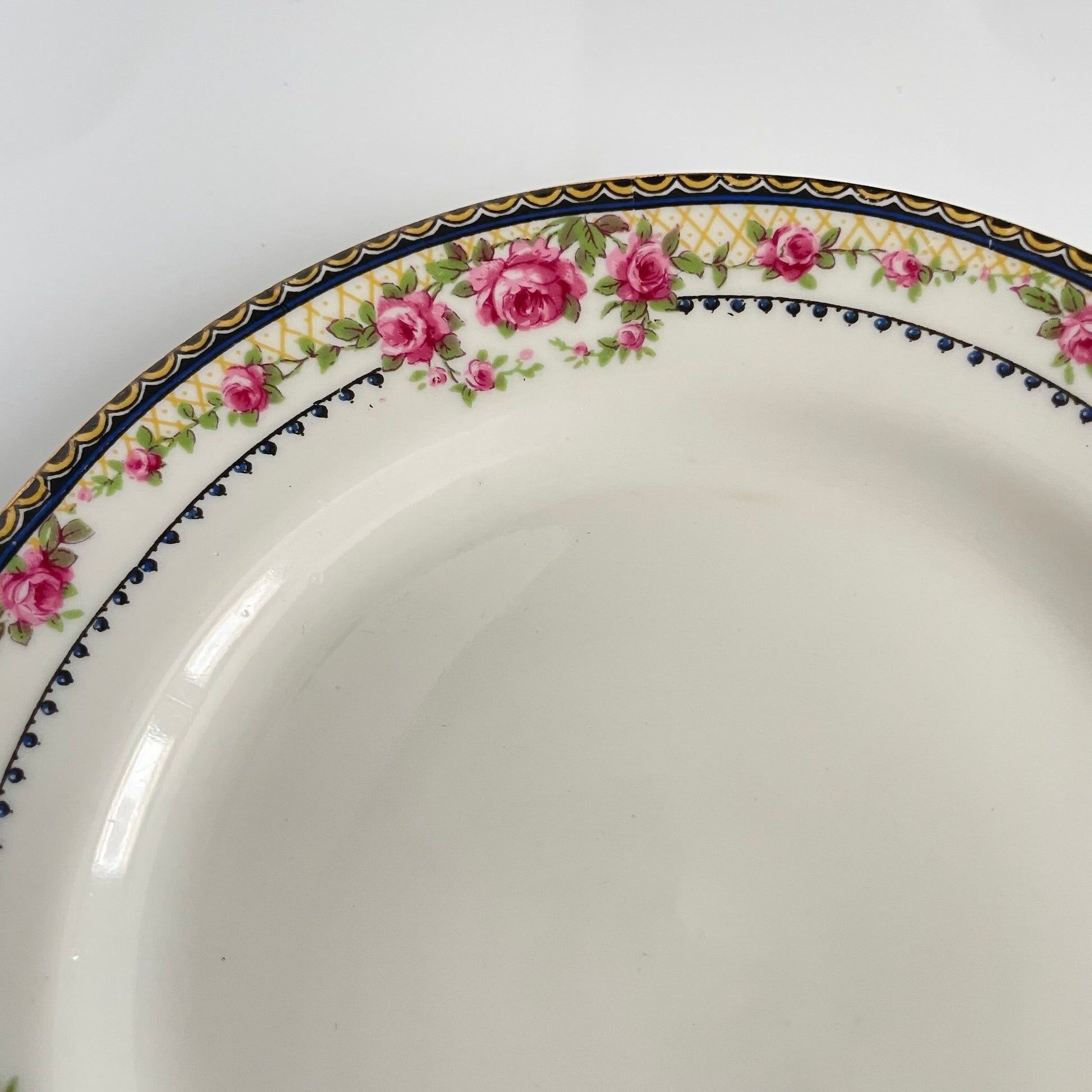 Pair of antique French Limoges porcelain dessert plates, 20th century. Delicate pink rose pattern on the rim, classic and elegant design.