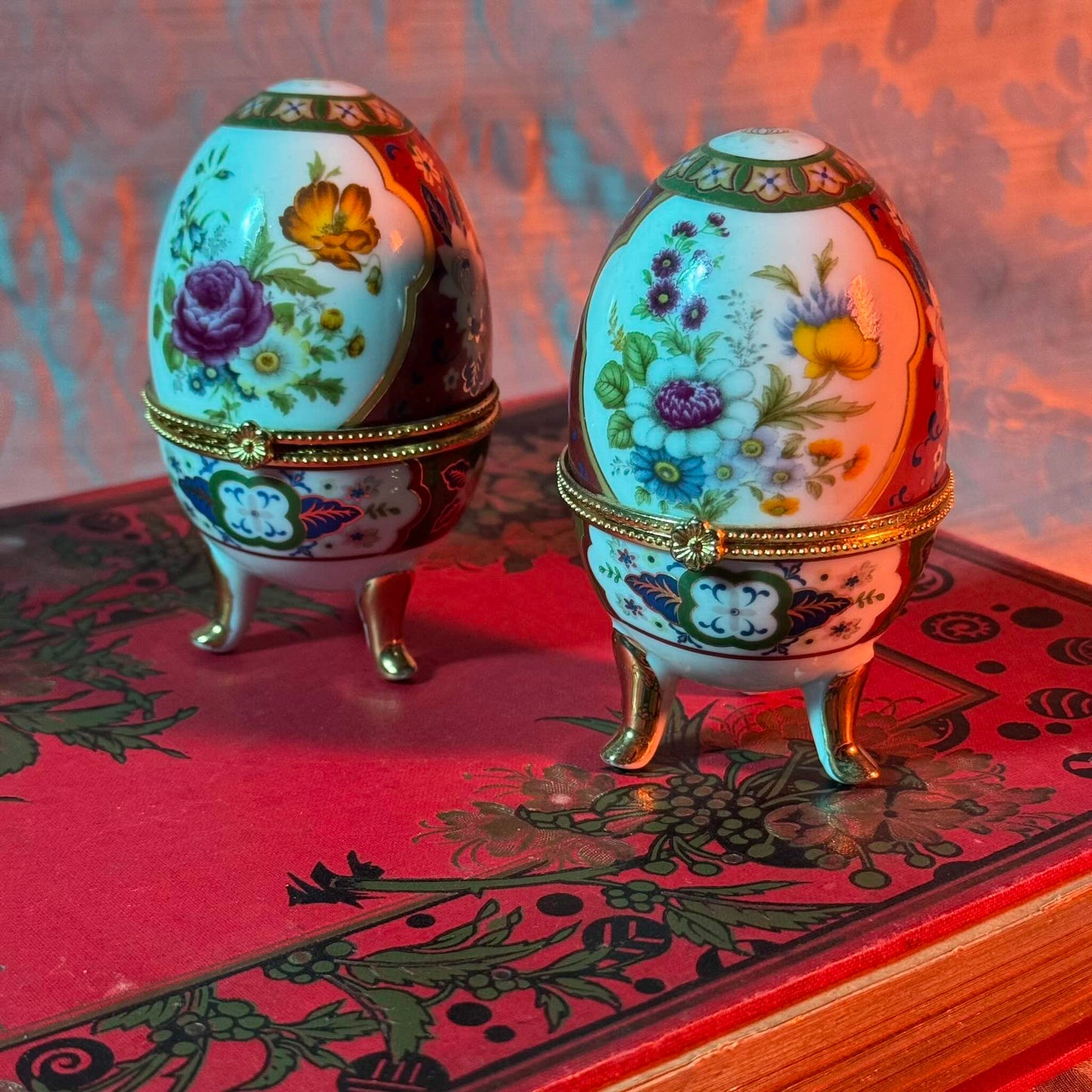 A charming set of two porcelain egg-shaped boxes with an elegant floral design. Their pretty decoration makes them perfect for storage or as decorative pieces. Vintage from the 20th century onwards.