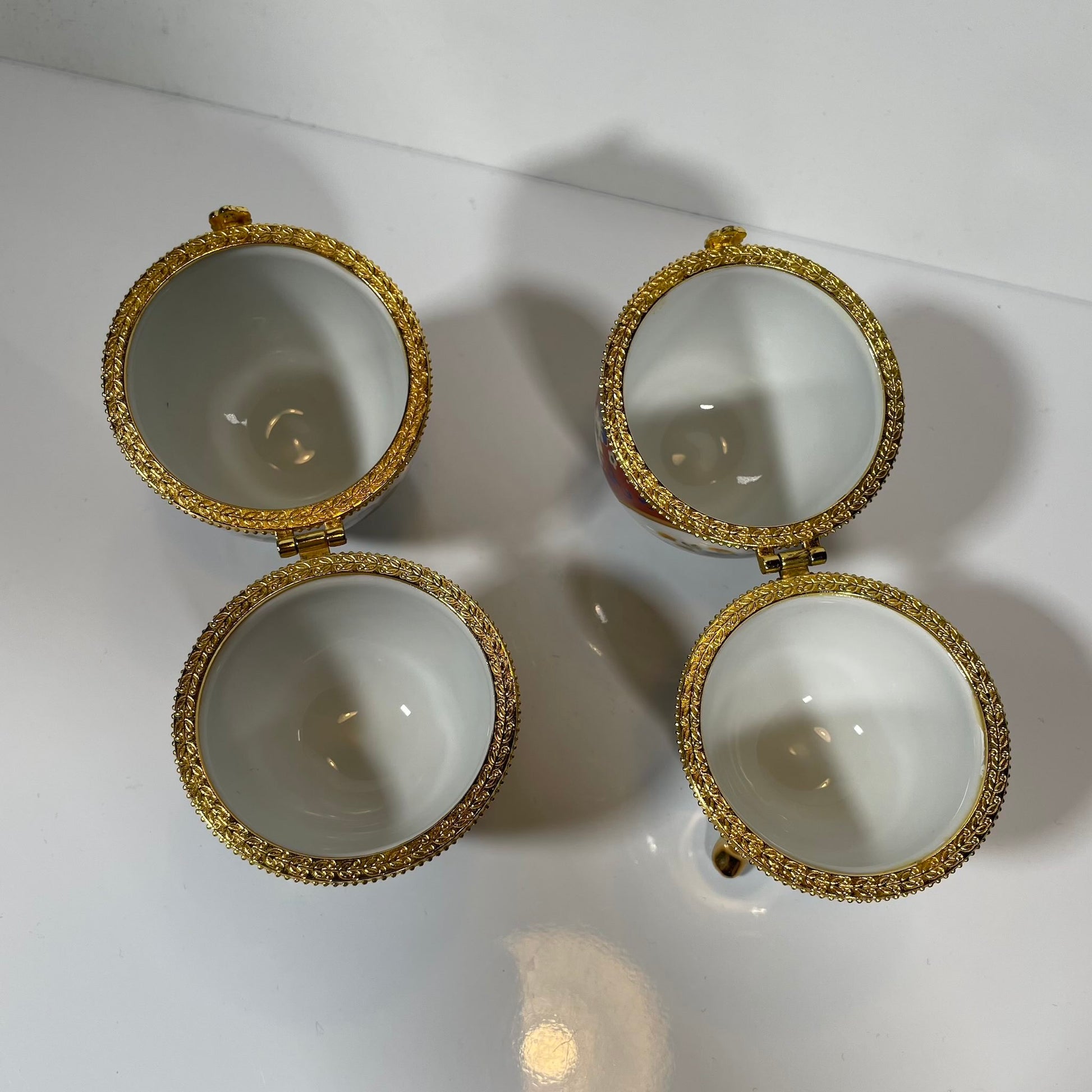 A charming set of two porcelain egg-shaped boxes with an elegant floral design. Their pretty decoration makes them perfect for storage or as decorative pieces. Vintage from the 20th century onwards.