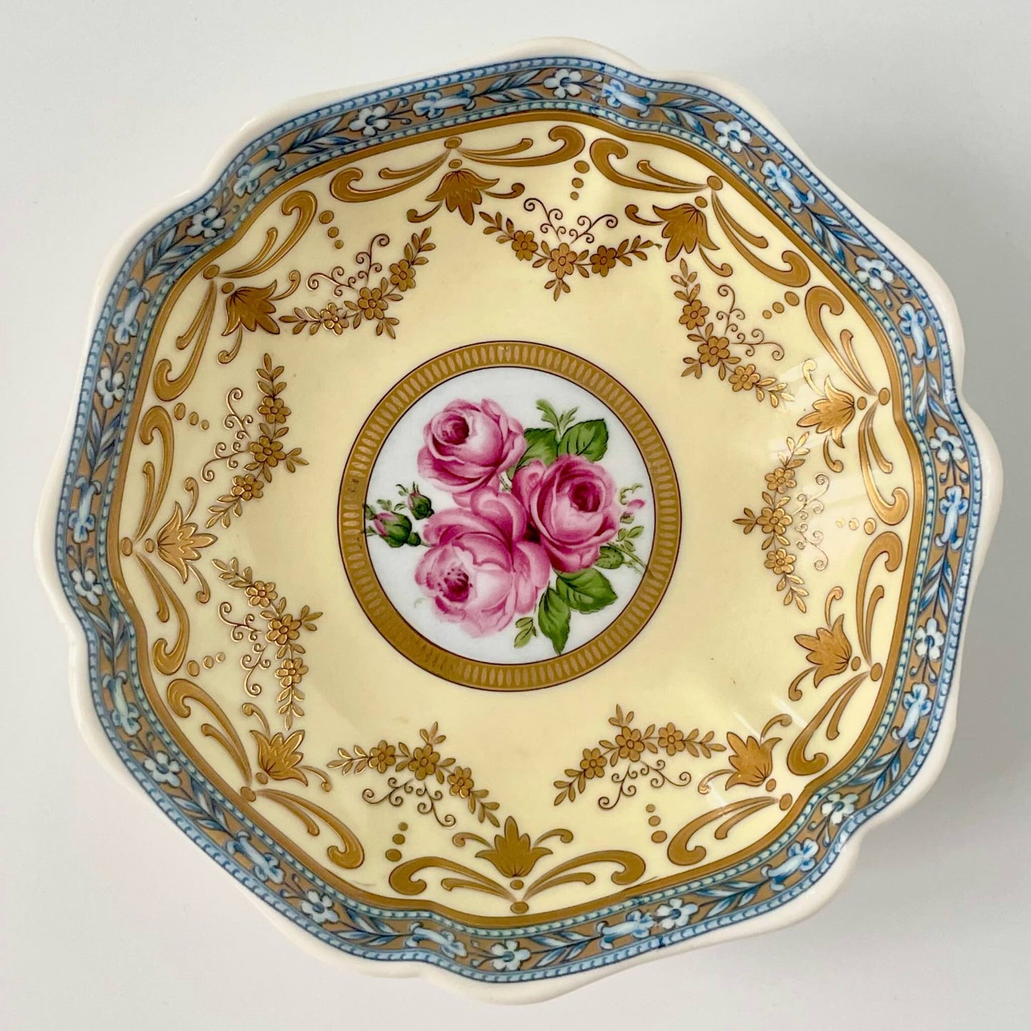 Porcelain trinket tray inspired by 18th-century Sèvres, featuring delicate roses and a golden garland, adding elegance to any room.