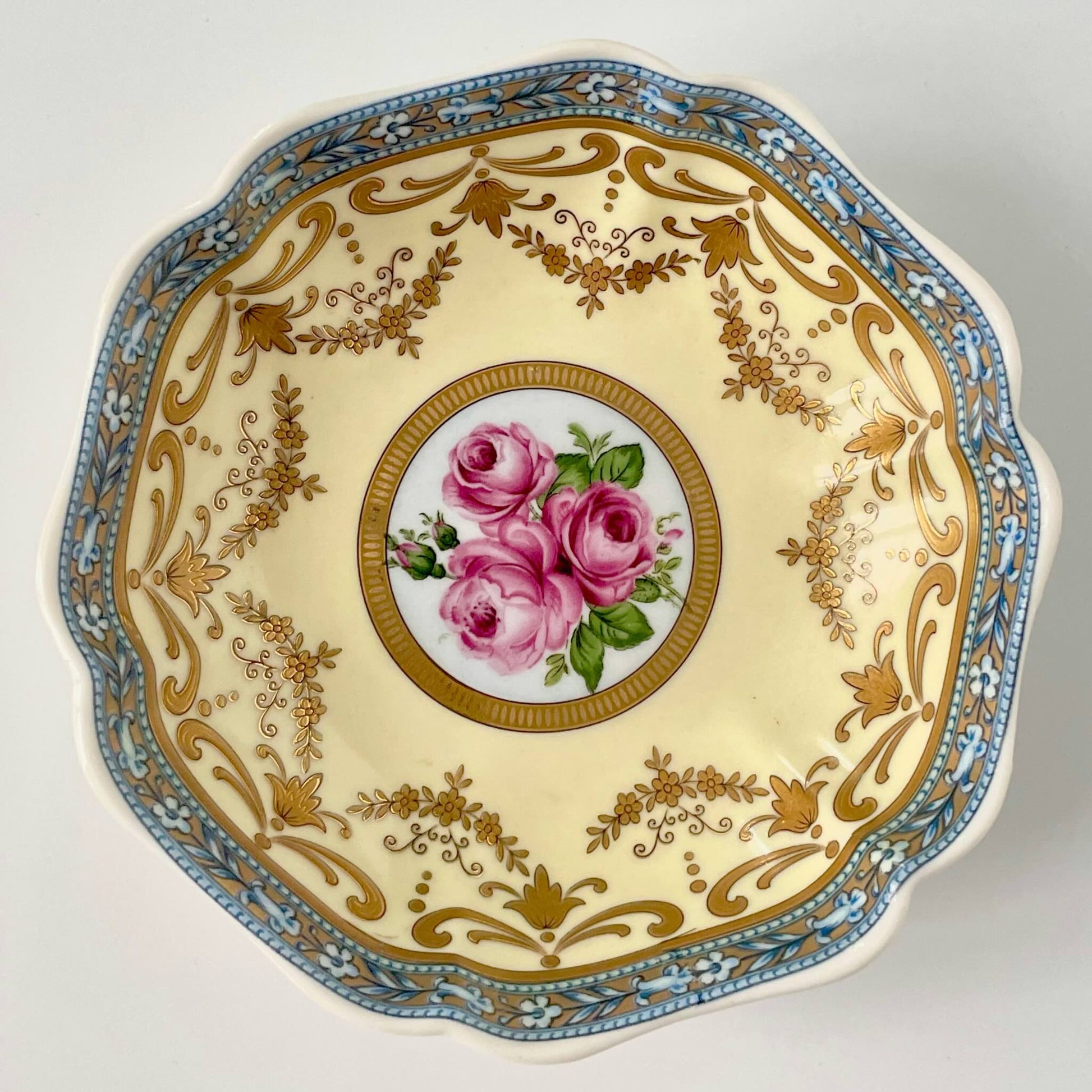 Porcelain trinket tray inspired by 18th-century Sèvres, featuring delicate roses and a golden garland, adding elegance to any room.