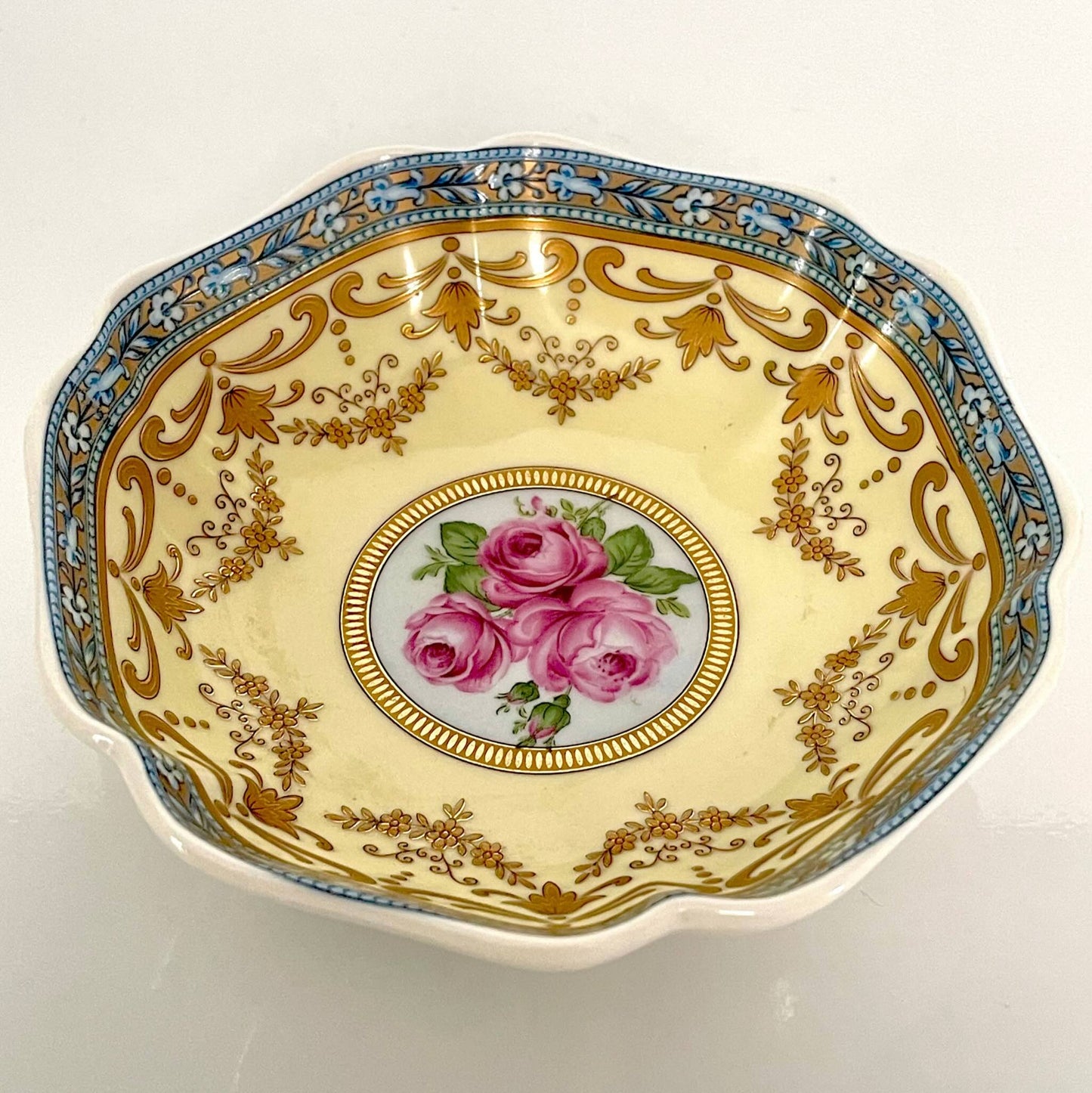 Porcelain trinket tray inspired by 18th-century Sèvres, featuring delicate roses and a golden garland, adding elegance to any room.