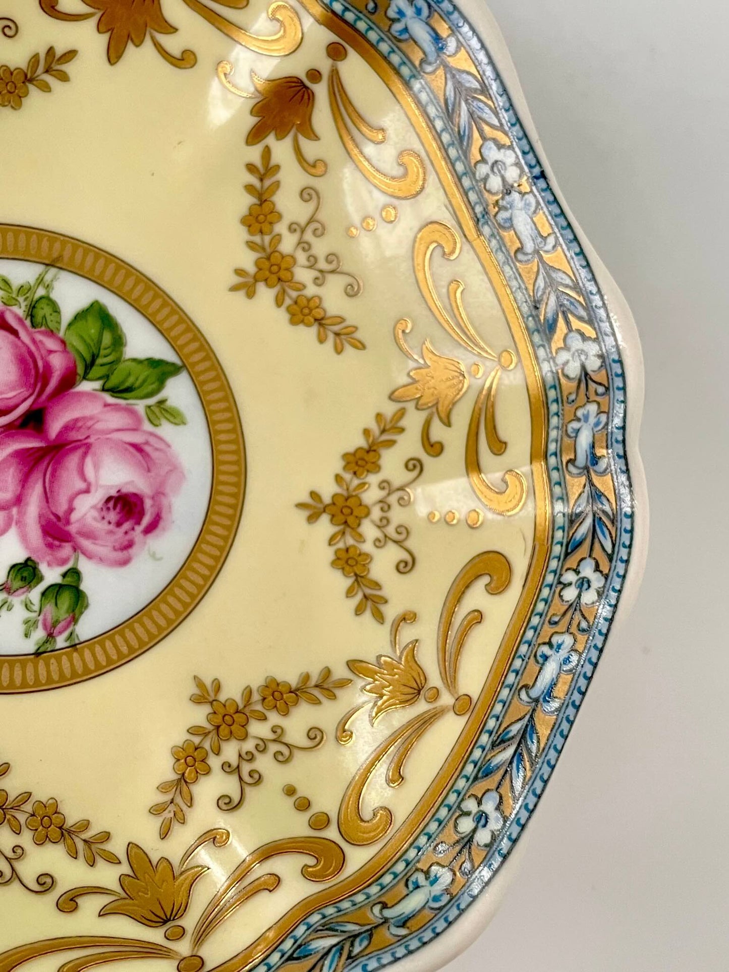 Porcelain trinket tray inspired by 18th-century Sèvres, featuring delicate roses and a golden garland, adding elegance to any room.