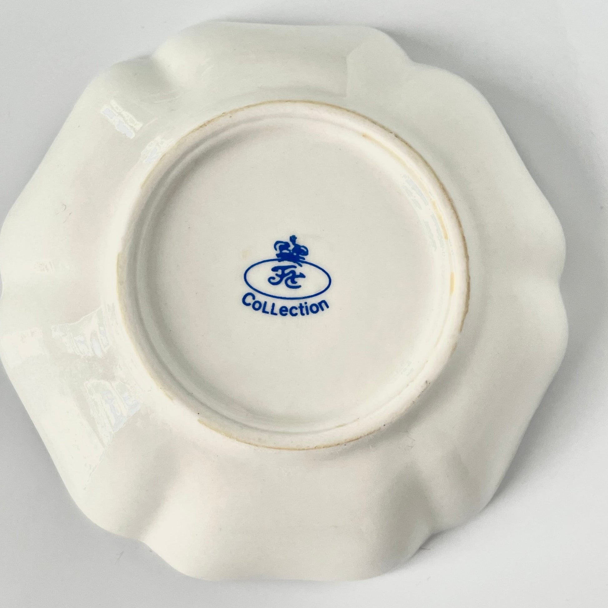 Porcelain trinket tray inspired by 18th-century Sèvres, featuring delicate roses and a golden garland, adding elegance to any room.