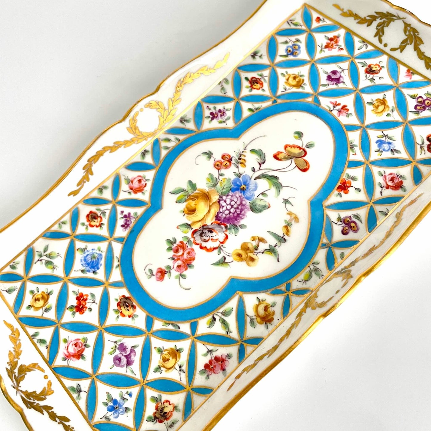 English: Hand-painted porcelain tray, Sèvres-style floral bouquet with scattered flowers and gilded decoration, late 19th to early 20th century, signed h g.; 日本語: 手描きの磁器トレイ、セーブル風の花束と小花模様、金彩装飾付き、19世紀後期〜20世紀初頭、h g.のサインあり; Français: Plateau en porcelaine peint à la main, décor floral de style Sèvres avec fleurs dispersées et dorure, fin XIXe – début XXe siècle, signé h g.
