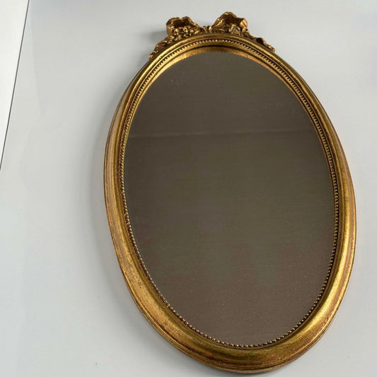 Vintage Louis XVI style gilded oval mirror, ribbon and rose crest, pearl border, 20th century France.