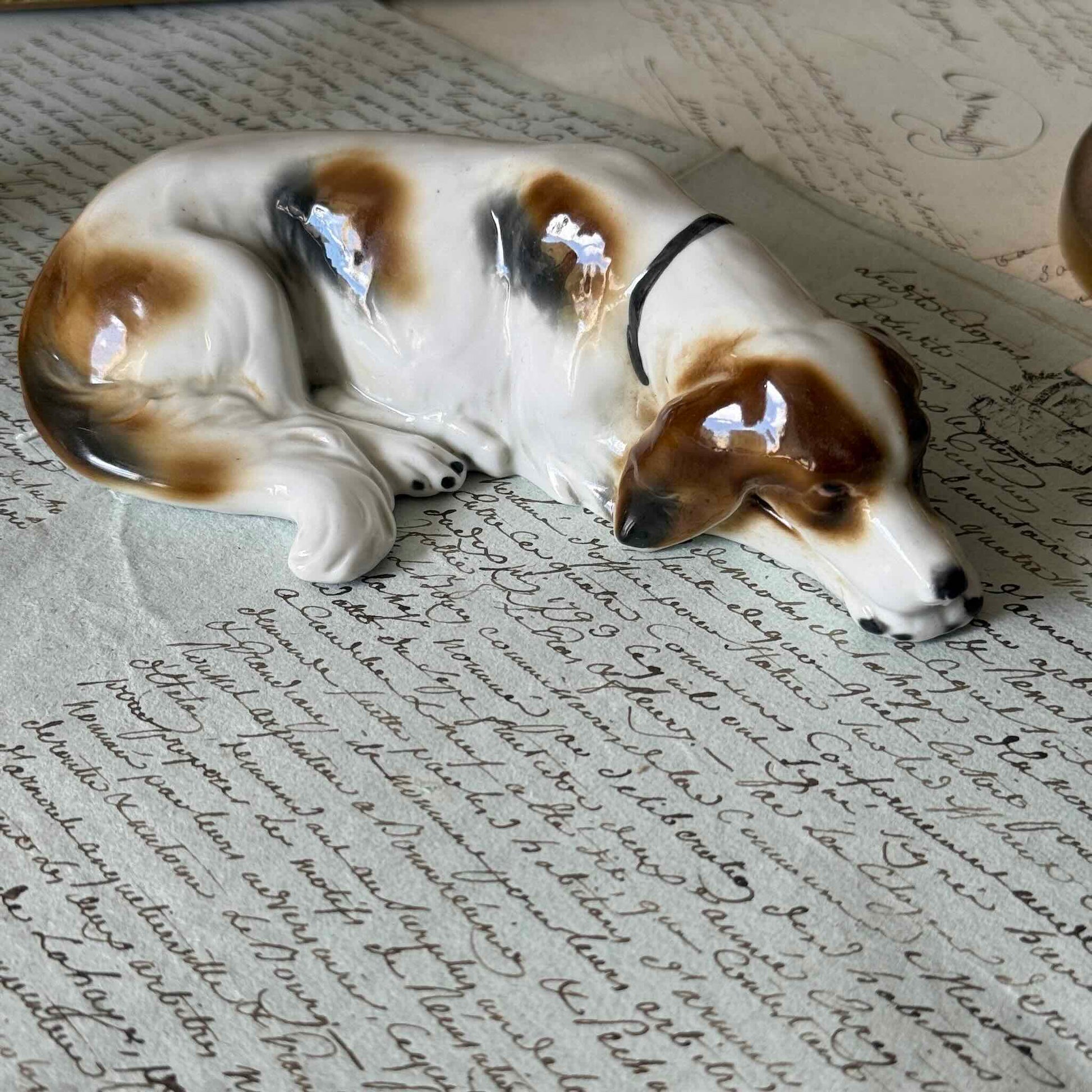 Vintage Goebel porcelain figurine of a sleeping hunting dog, hand-painted brown and white coat, circa 1935 Germany.