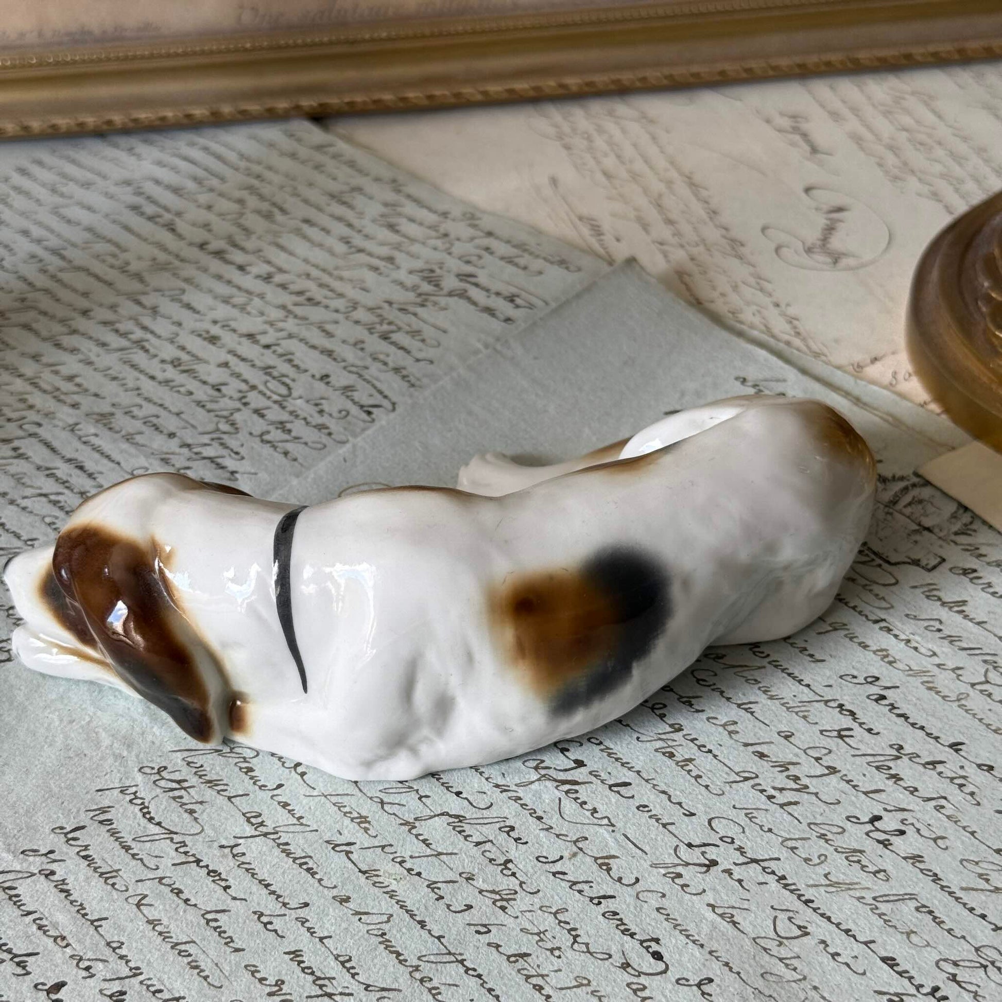 Vintage Goebel porcelain figurine of a sleeping hunting dog, hand-painted brown and white coat, circa 1935 Germany.