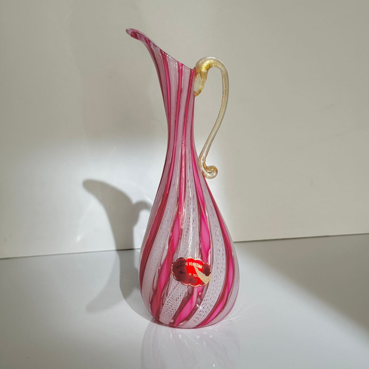 Vintage Murano glass ewer vase featuring pink and white latticino filigree patterns, mid-20th century Italy.