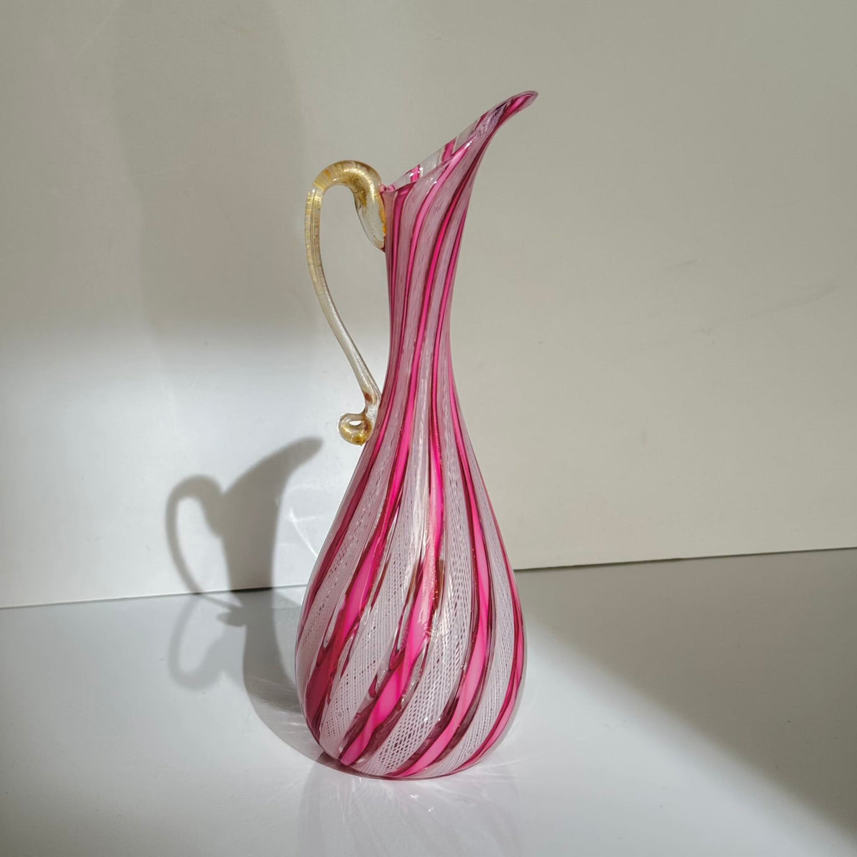 Vintage Murano glass ewer vase featuring pink and white latticino filigree patterns, mid-20th century Italy.