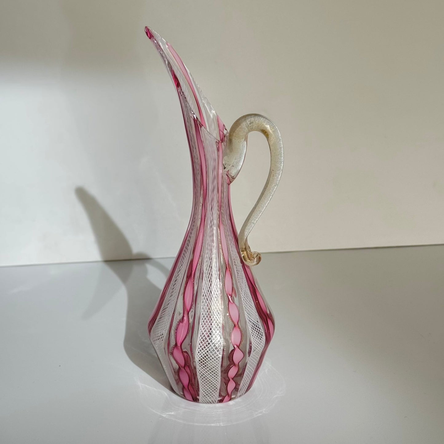 Vintage Murano glass ewer vase featuring pink and white latticino filigree patterns, mid-20th century Italy.